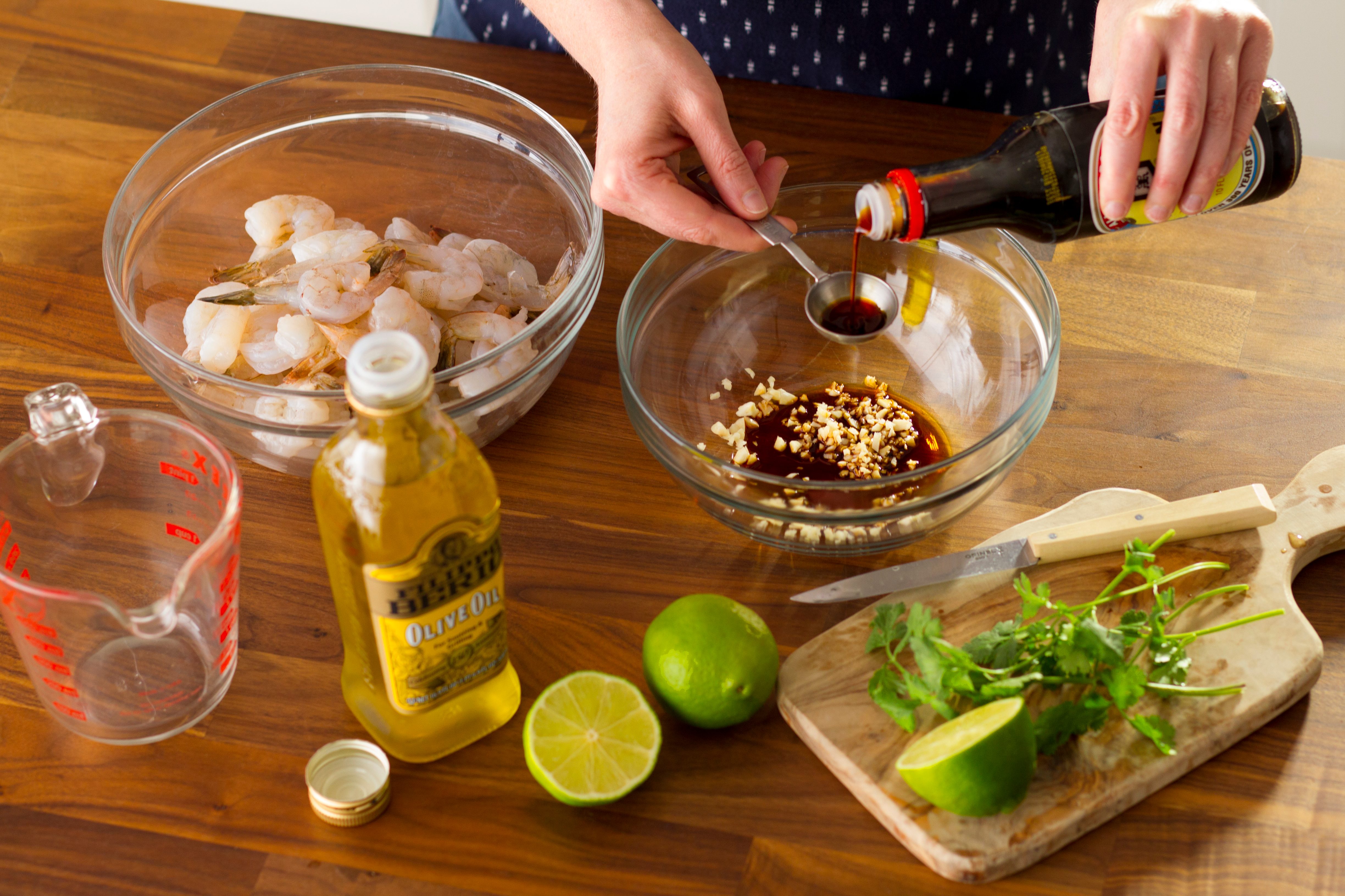 Person measuring soy sauce to pour into a bowl
