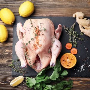 Composition with whole raw turkey and some products on slate plate