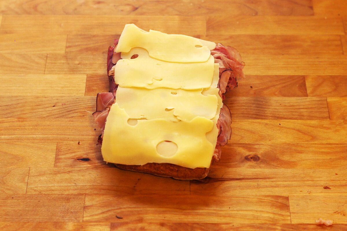 Meat and cheese layered together on a slice of bread