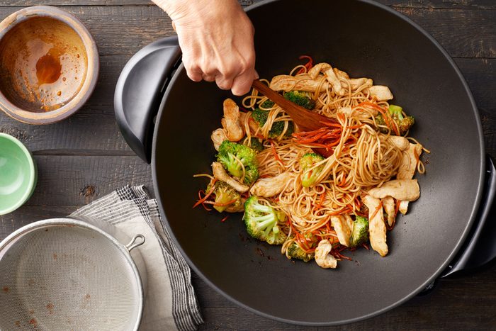 A Person Stirring Food in a Wok