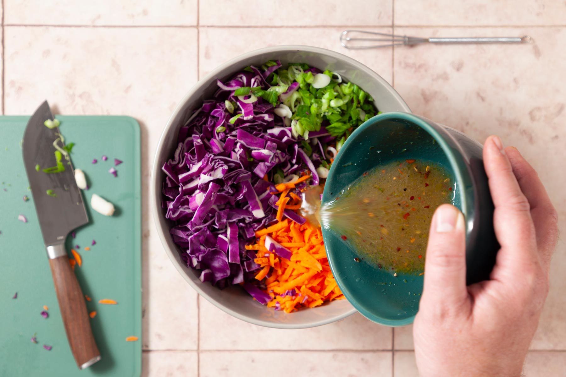 A Person Pouring Dressing Into a Bowl of Salad