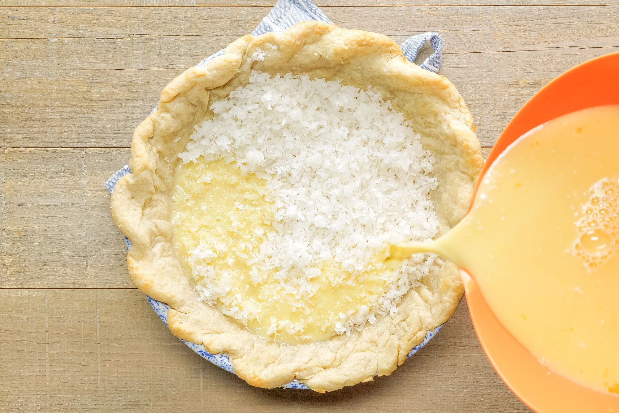 Pouring Egg and Milk Mix on Coconut Custard Pie Crust