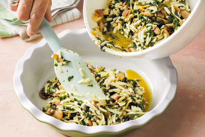 Pouring Spinach Quiche Mix into a Pie Plate