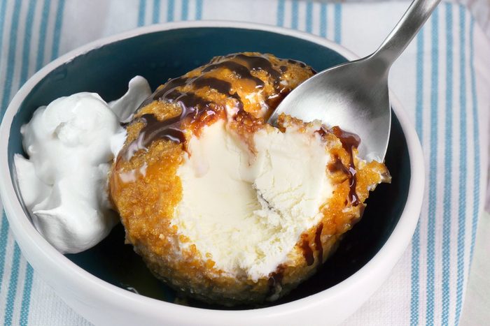 3/4th shot; white wooden background; Fried Ice Cream served in a small bowl over kitchen towel