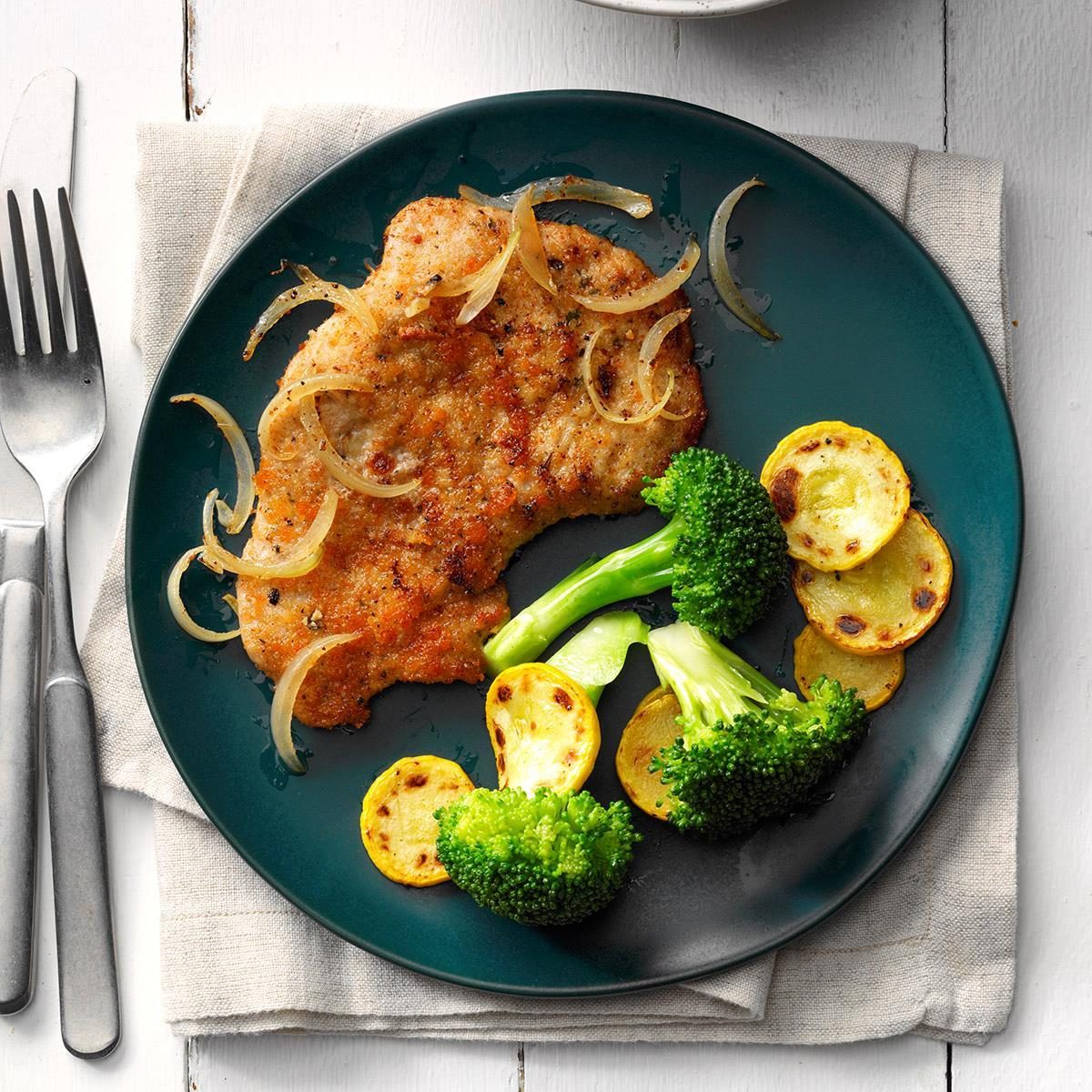 A plate with Parmesan Pork Medallions and roasted vegetables