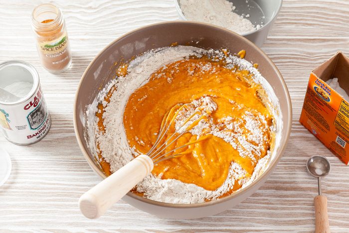 Mixing Dry Ingredients In A Large Bowl on Wooden Surface to Make Pumpkin Chocolate Chip Muffins