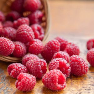 Fresh and tasty looking raspberries on a wooden table