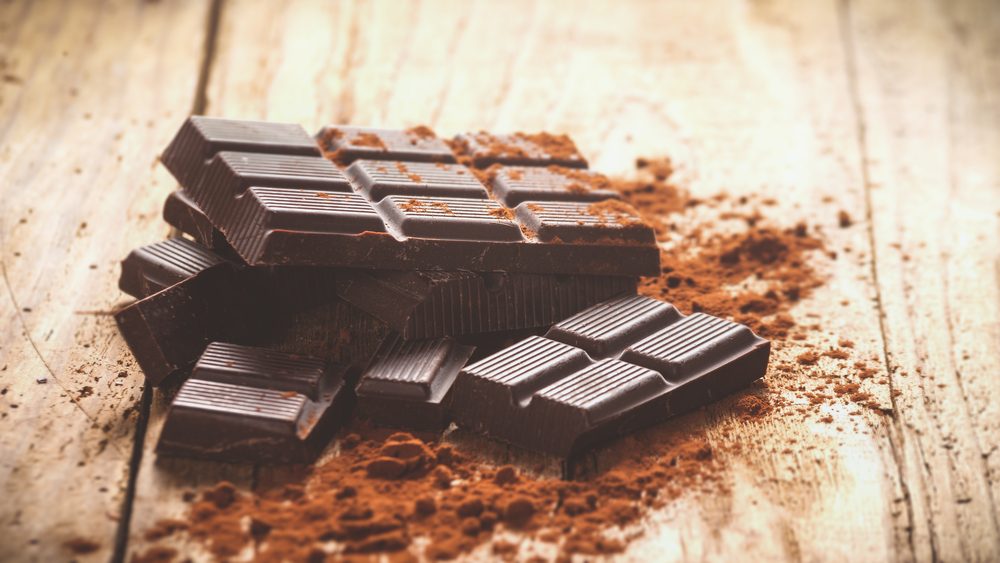 Dark chocolate on a wooden table. Acceptable on Keto diet