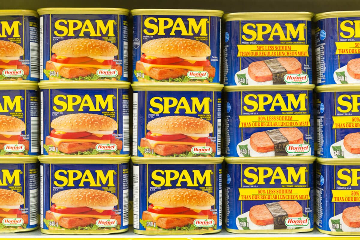 Spam canned meat stacked vertically in store shelf.