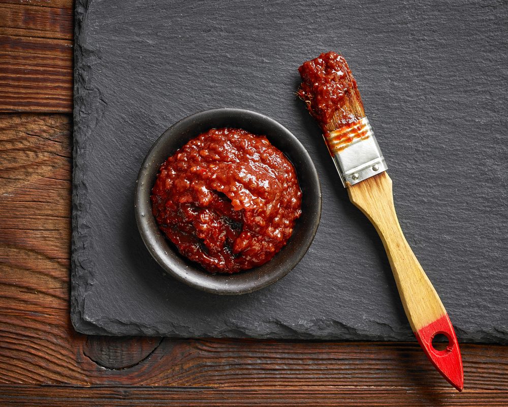 bowl of chili, tomato and garlic sauce on black stone