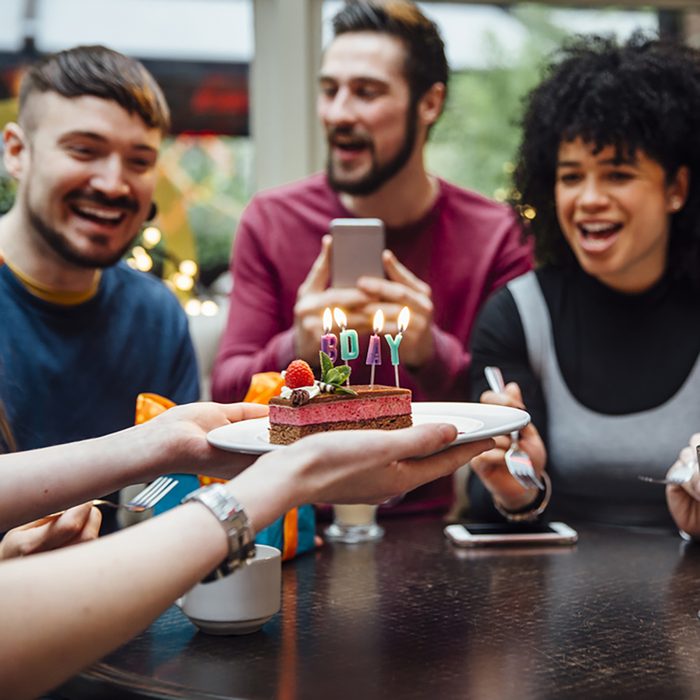 Group of friends are in a bar celebrating on of the women's birthdays.
