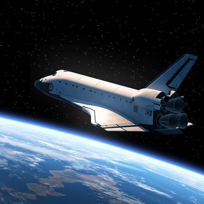 Space Shuttle Orbiting Earth. 3D Scene.