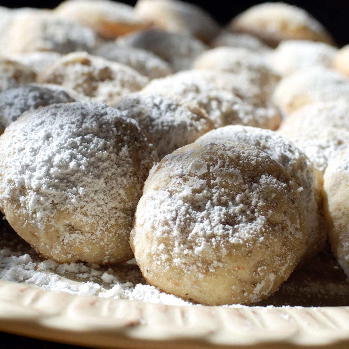 Close up to mexican wedding cookie in darkened kitchen counter