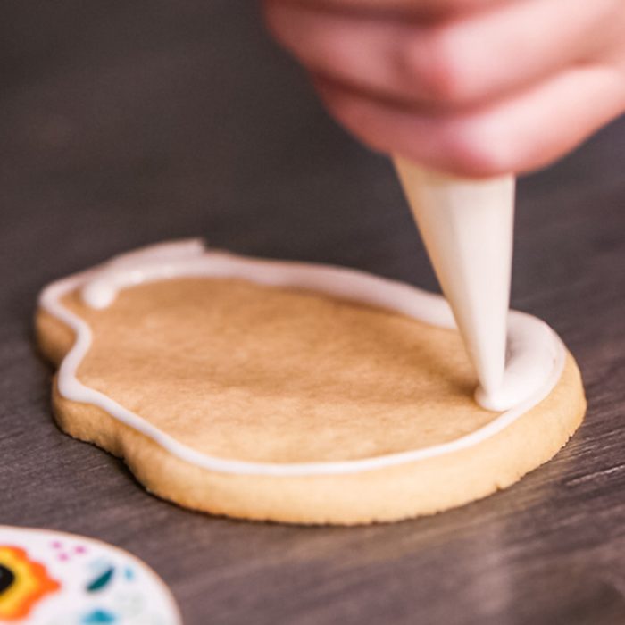 Step by step. Flooding a sugar skull cookie with white royal icing.