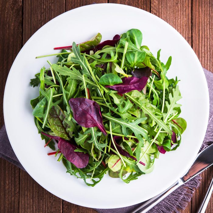 Fresh salad plate with mixed greens (arugula, mesclun, mache) on dark wooden background top view. Healthy food. Green meal.; Shutterstock ID 534979237; Job (TFH, TOH, RD, BNB, CWM, CM): TOH