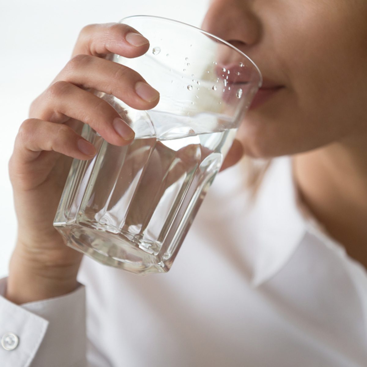 Dehydrated woman feeling thirsty holding glass drinking filtered pure mineral fresh water