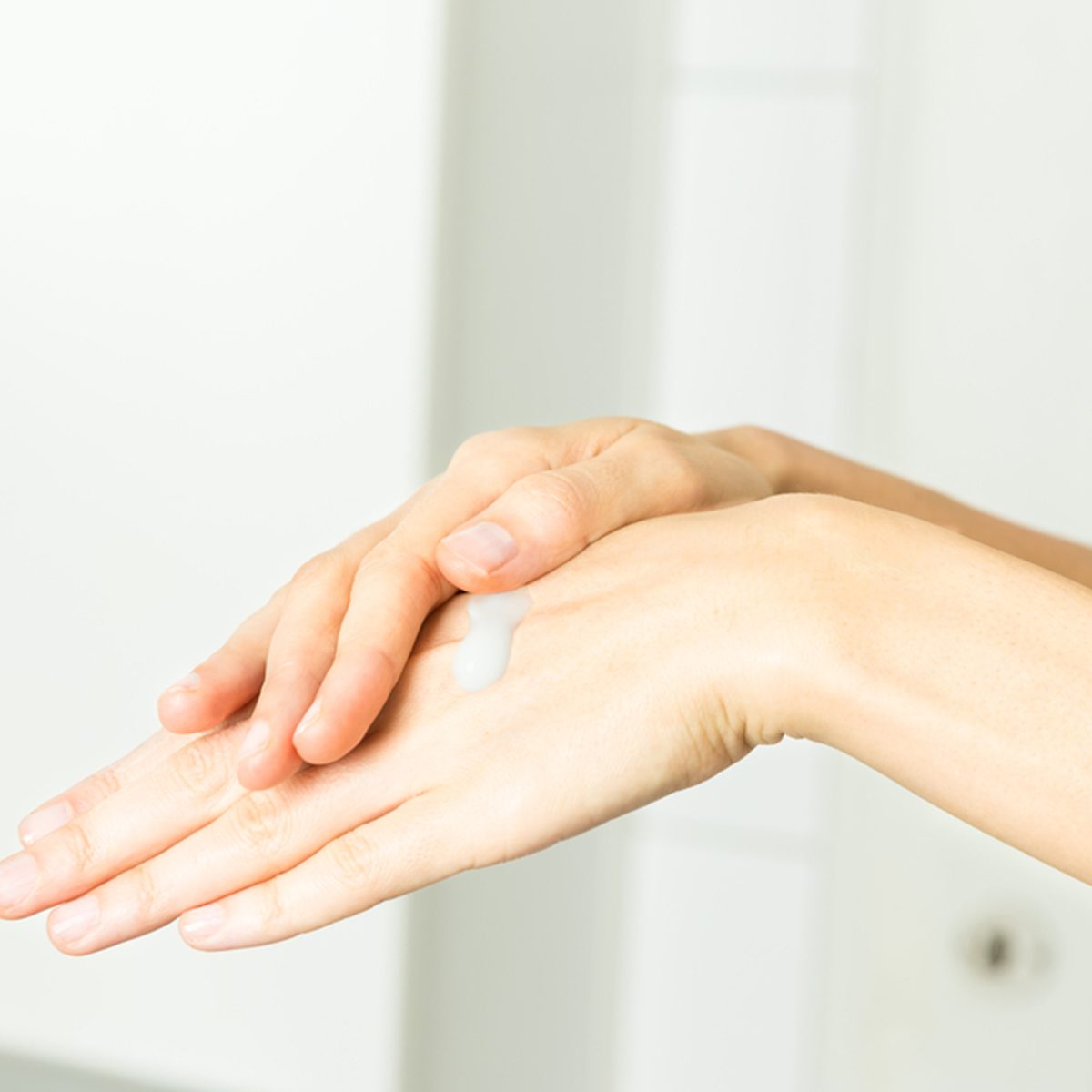 Female hands applying cream
