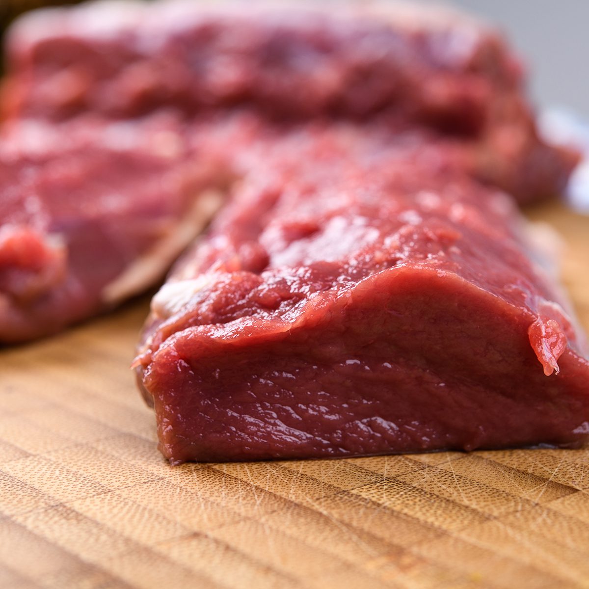 Saddle of venison on wooden board with big knife