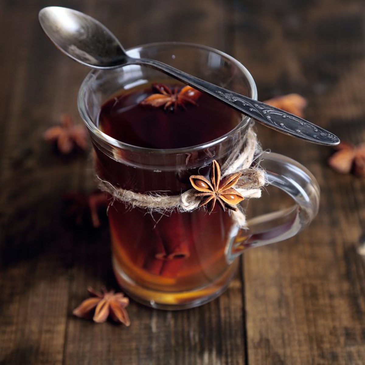 Apple cider vinegar in a glass with spoon and spices