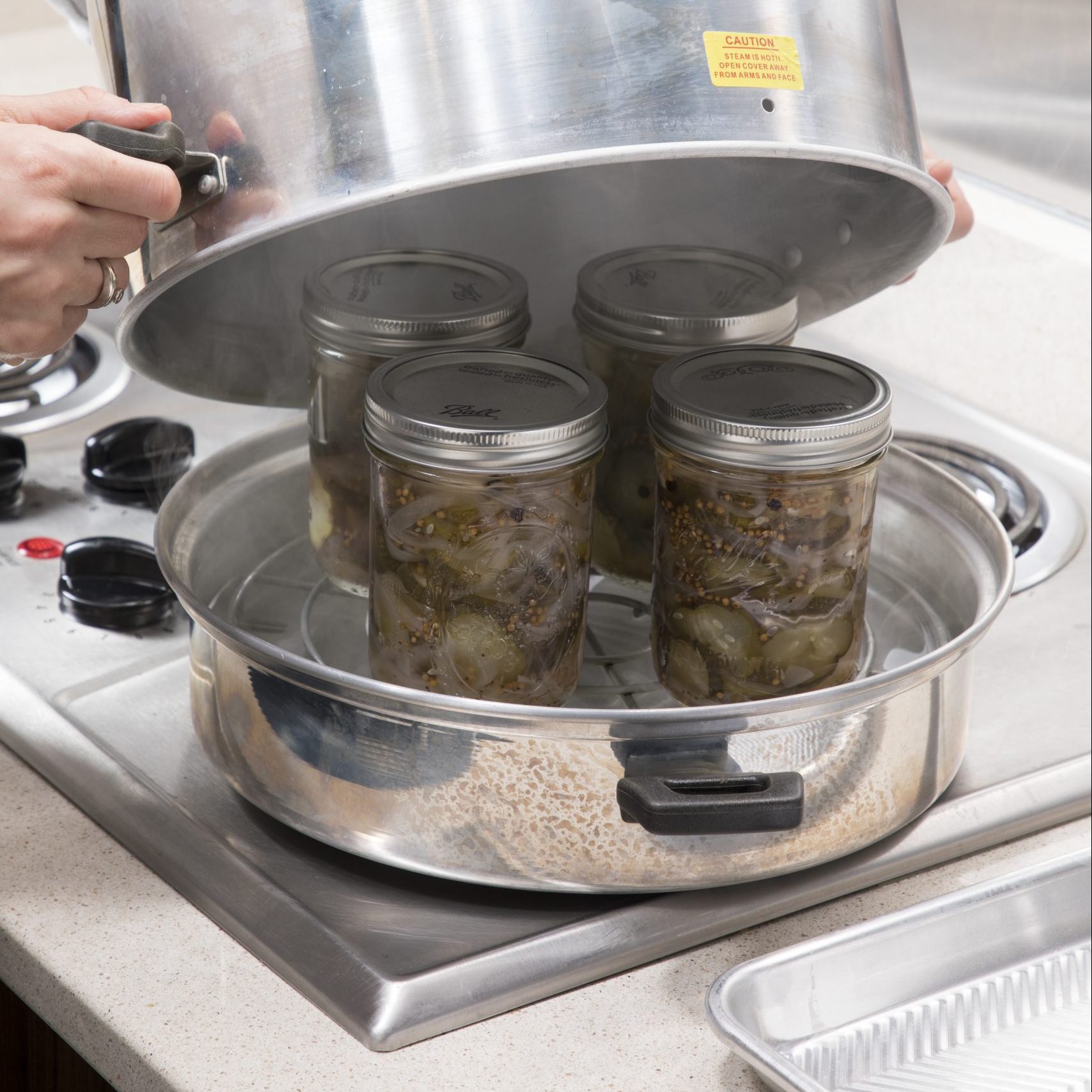 Jars Sitting On The Steam Canner Rack And The Lid Starting To Go Over The Jars
