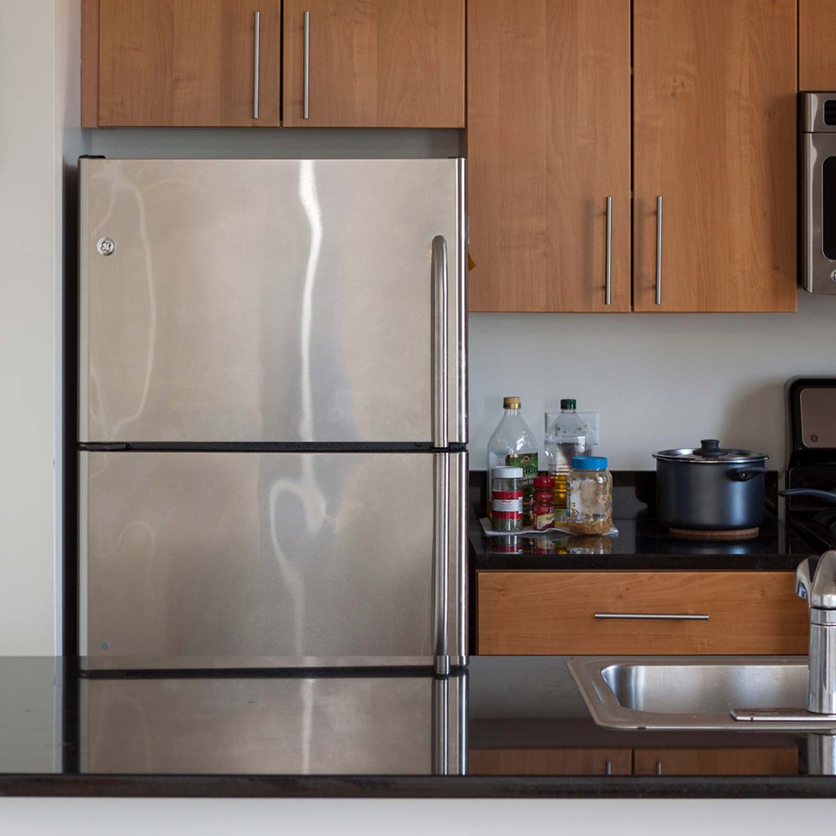 Fridge among cabinets