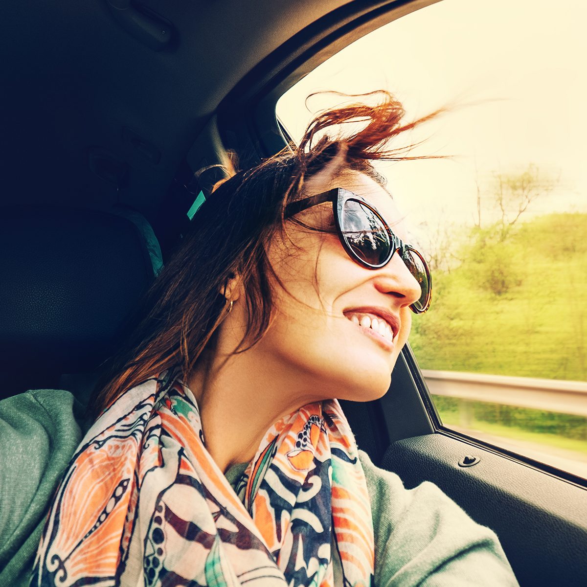 Woman feels free and looks out from open window car