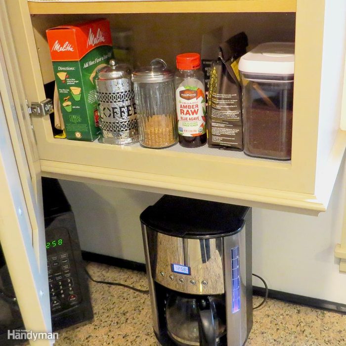 a short shelf in the cabinet nearest the coffee maker