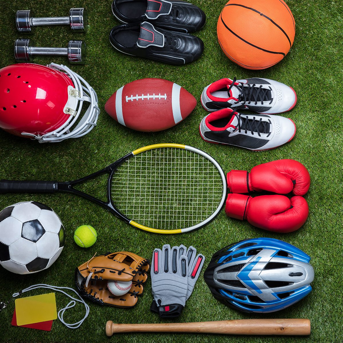 High Angle View Of Various Sport Equipments On Green Grass