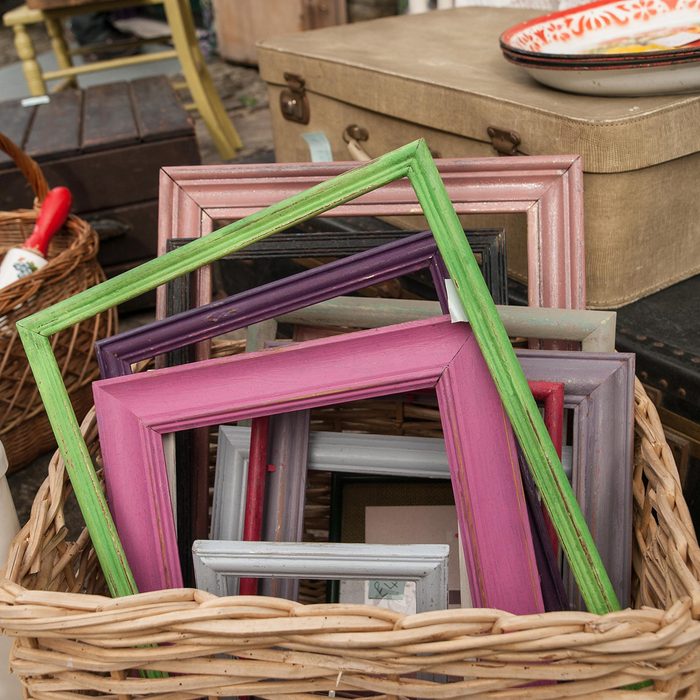 Differed coloured painted wood frames in a basket for sale at a vendor in Hay-on-Wye, Wales, United Kingdom, Europe.