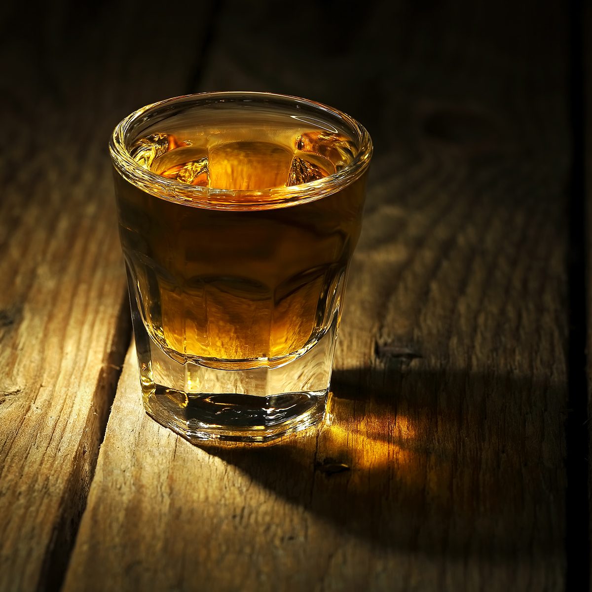shot of whiskey on old wooden surface