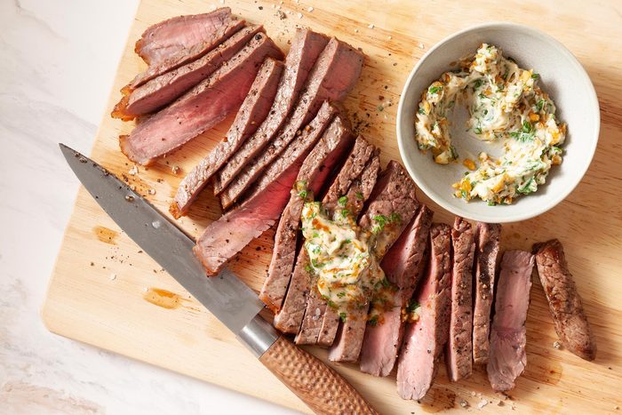 A Cutting Board With Steak and a Knife