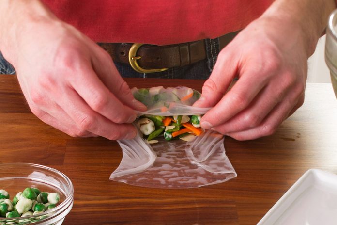 A person wrapping homemade spring rolls.