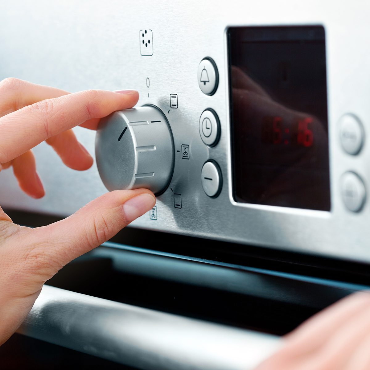 Close-up on woman's hands using a baking-oven.