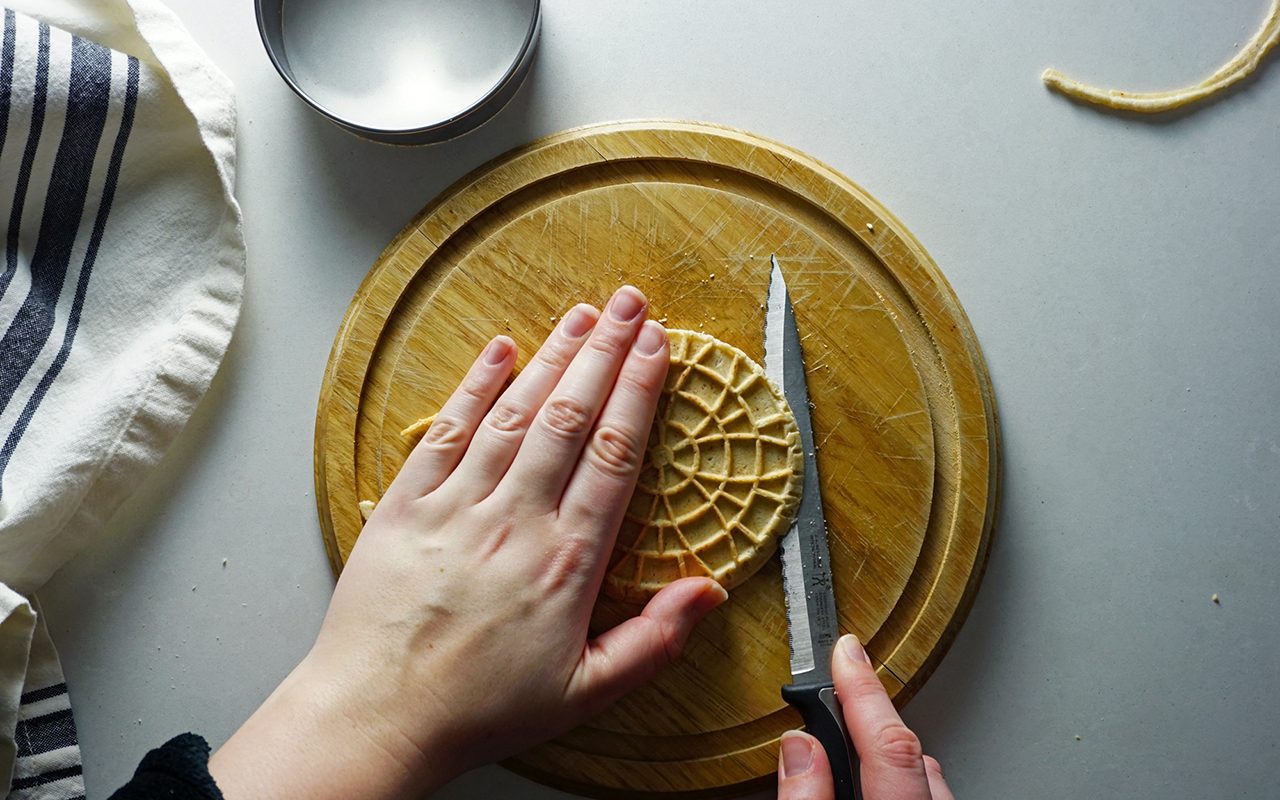 carefully cutting a stroopwafel in half