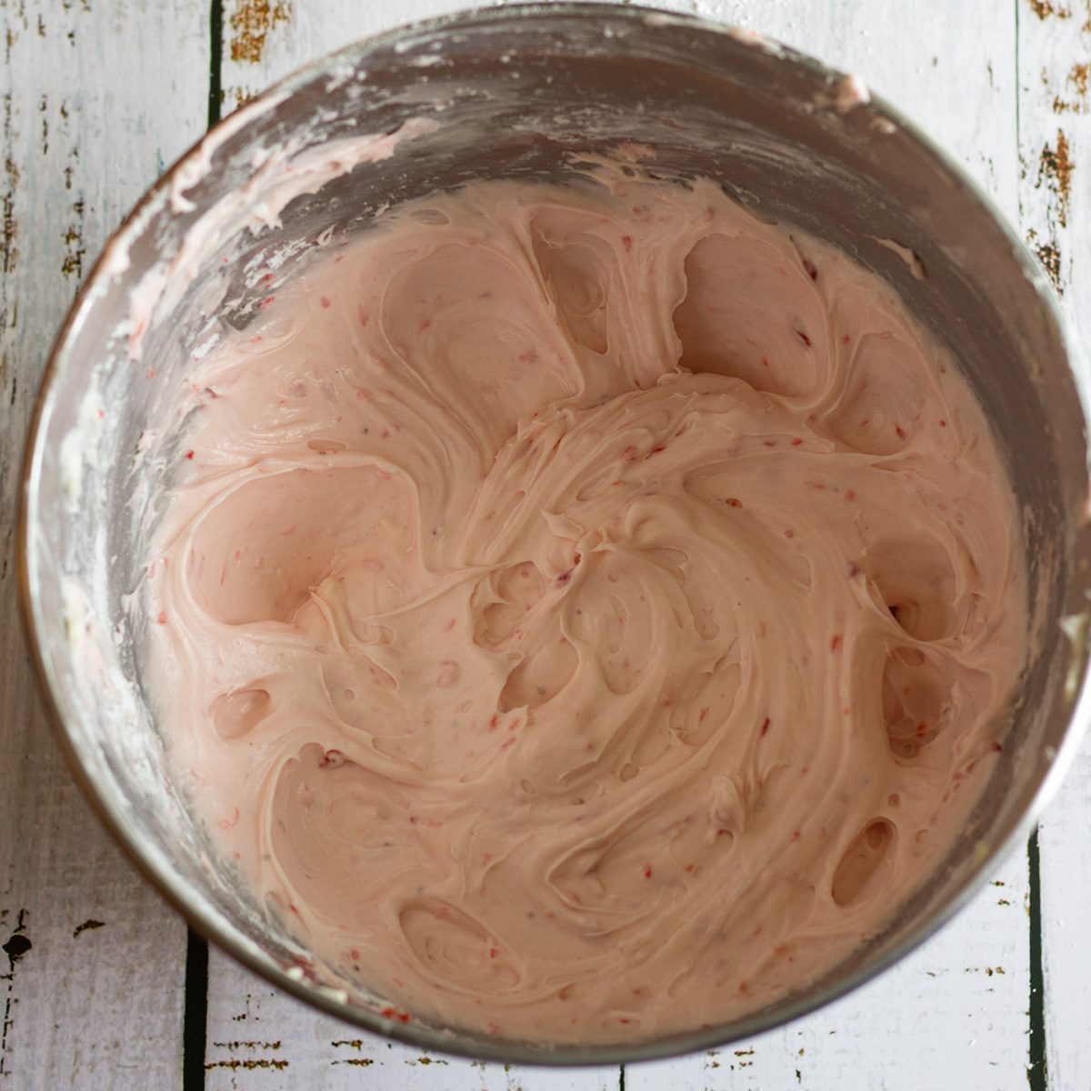 Mixing bowl holding strawberry cream cheese frosting.