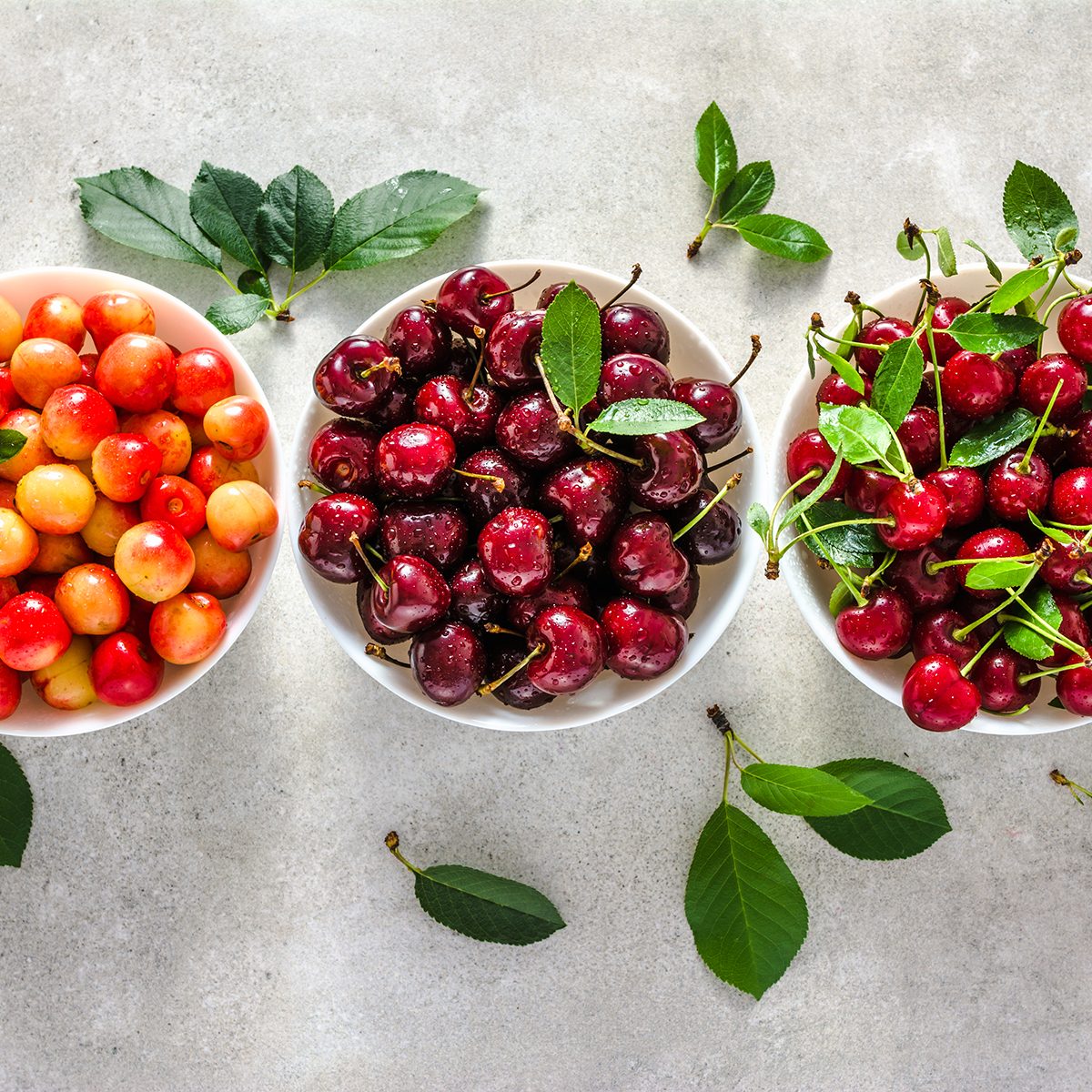 Different cherry on plate on white background, ripe cherries, sweet fruit, top view