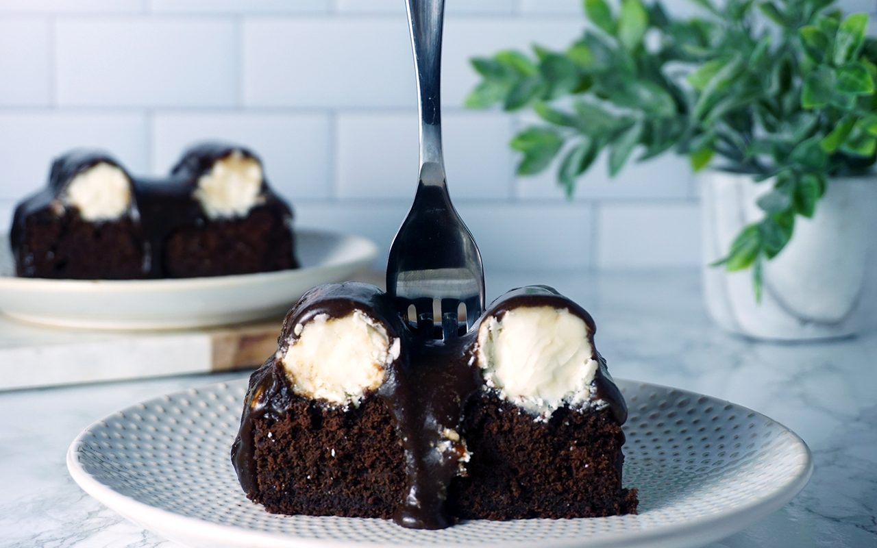 two slices of bumpy cake on white plates and a marble countertop