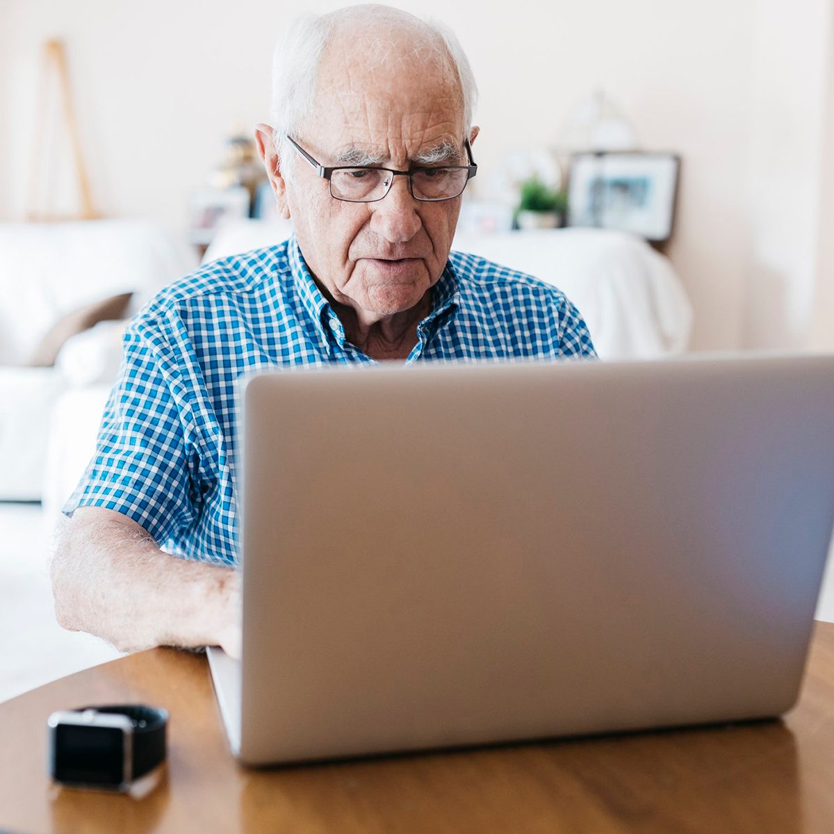 Porrtait of senior man at home learning to use laptop