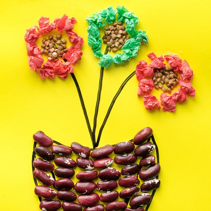 flower in pot from cereals, beans, dried leaves and colored paper Children's seasonal crafts from natural materials. Original children's art project. DIY creative handmade concept.