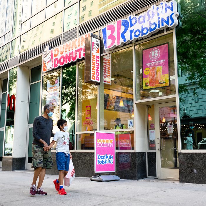 NEW YORK, NEW YORK - JULY 31: People wear protective face masks outside Dunkin' Donuts and Baskin-Robbins as the city continues Phase 4 of re-opening following restrictions imposed to slow the spread of coronavirus on July 31, 2020 in New York City. The fourth phase allows outdoor arts and entertainment, sporting events without fans and media production. (Photo by Noam Galai/Getty Images)