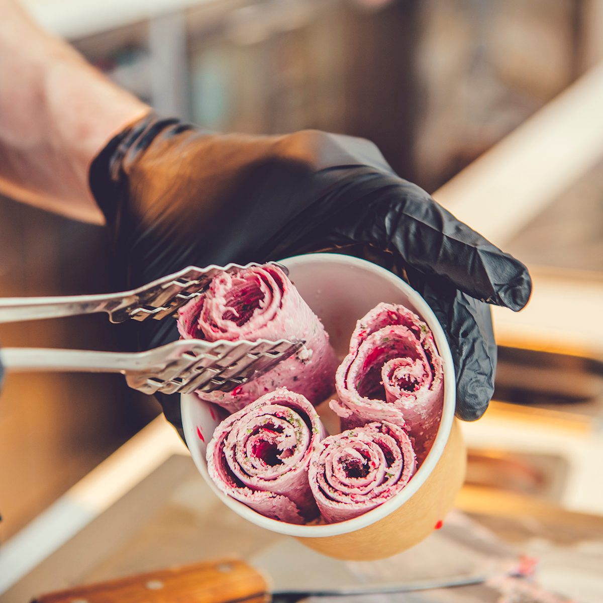 Preparing frozen ice cream made of fruit, cookies and mint at freeze pan