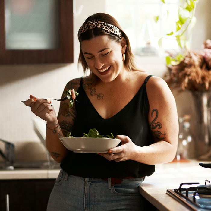 Shot of a young woman eating a healthy salad at home