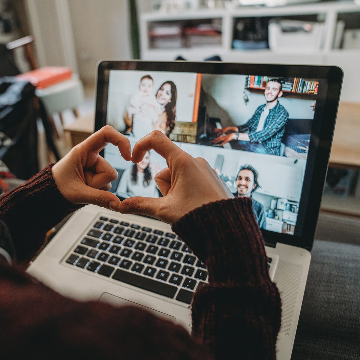 Young woman using a laptop to connect with her friends and parents during quarantine. She's having a video conference during Coronavirus COVID-19 time.