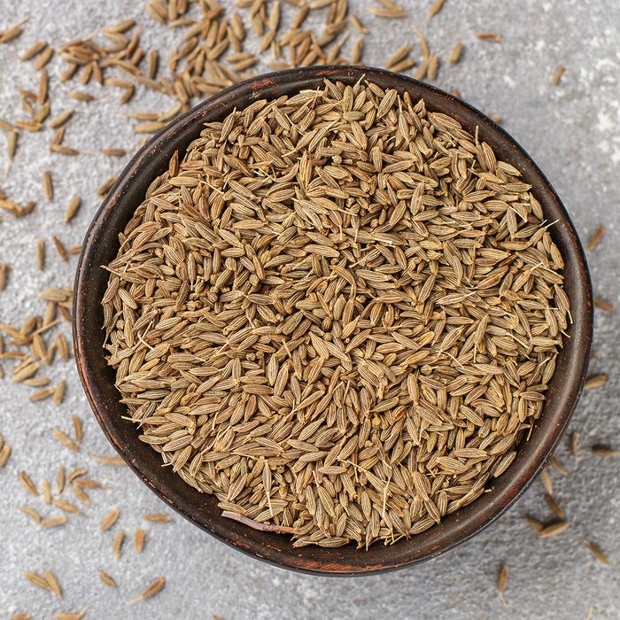 indian spices Cumin seeds (Zira) in a ceramic bowl close-up. Seasoning. Condiment. Selective focus. Top view and copy space