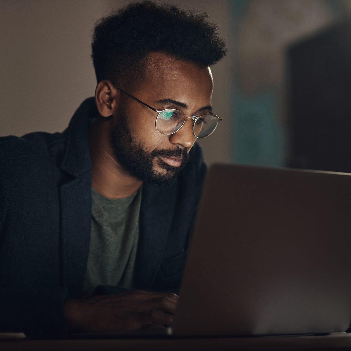 Shot of a young businessman using a laptop during a late night at work
