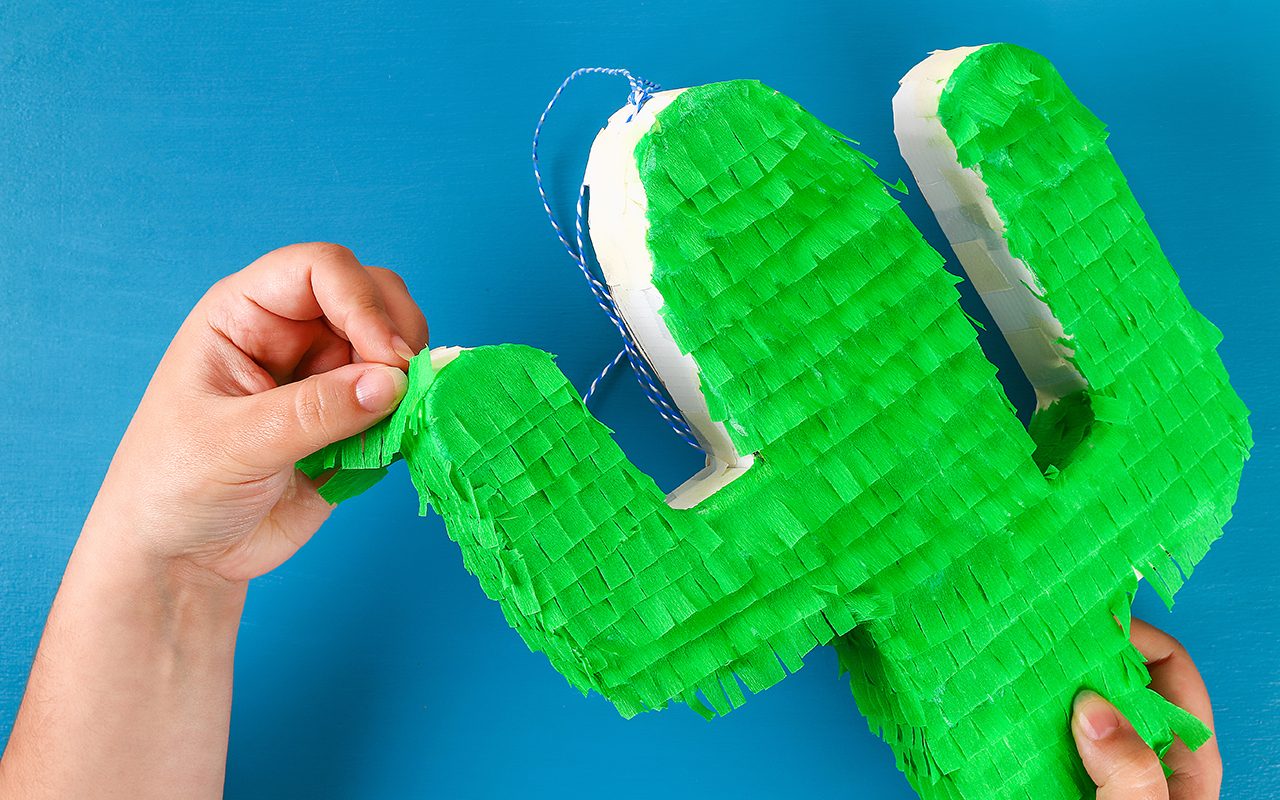 how to make a pinata Diy cinco de mayo Mexican Pinata Cactus made cardboard and crepe paper your own hands on a blue background. Gift idea, decor, game cinco de mayo. Step by step. Top view. Process kid children craft.