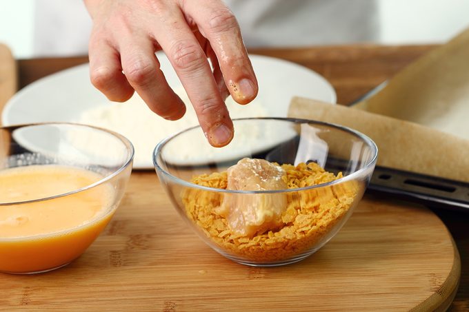 Roll Floured, Egged Chicken Fillet In Corn Flake Crumbs