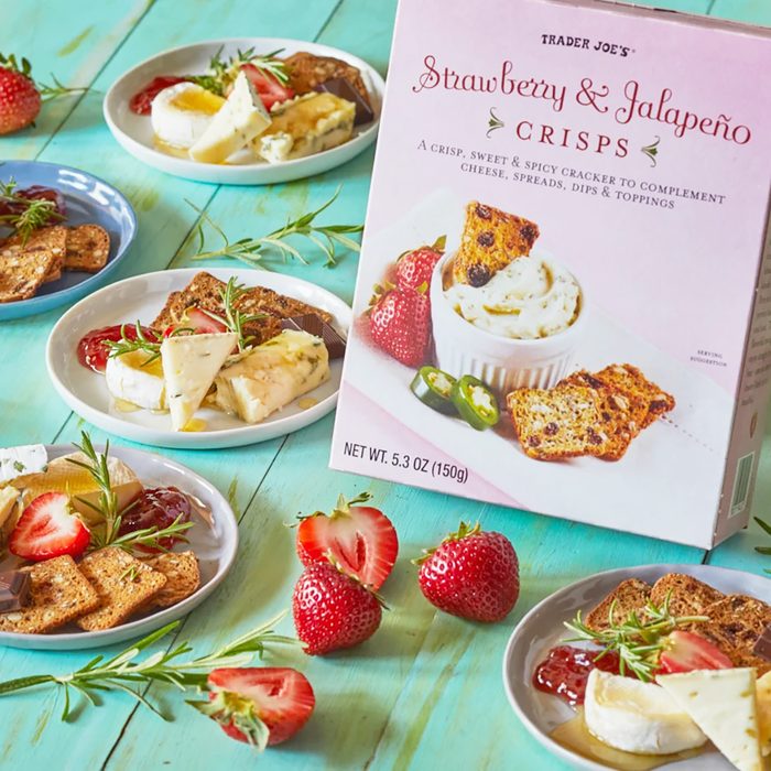 several mini plates with assorted cheese and crackers surround a box of Trader Joe's Strawberry & Jalapeño Crisps