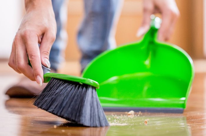 Adult Woman Sweeping Dirty Floor Indoors