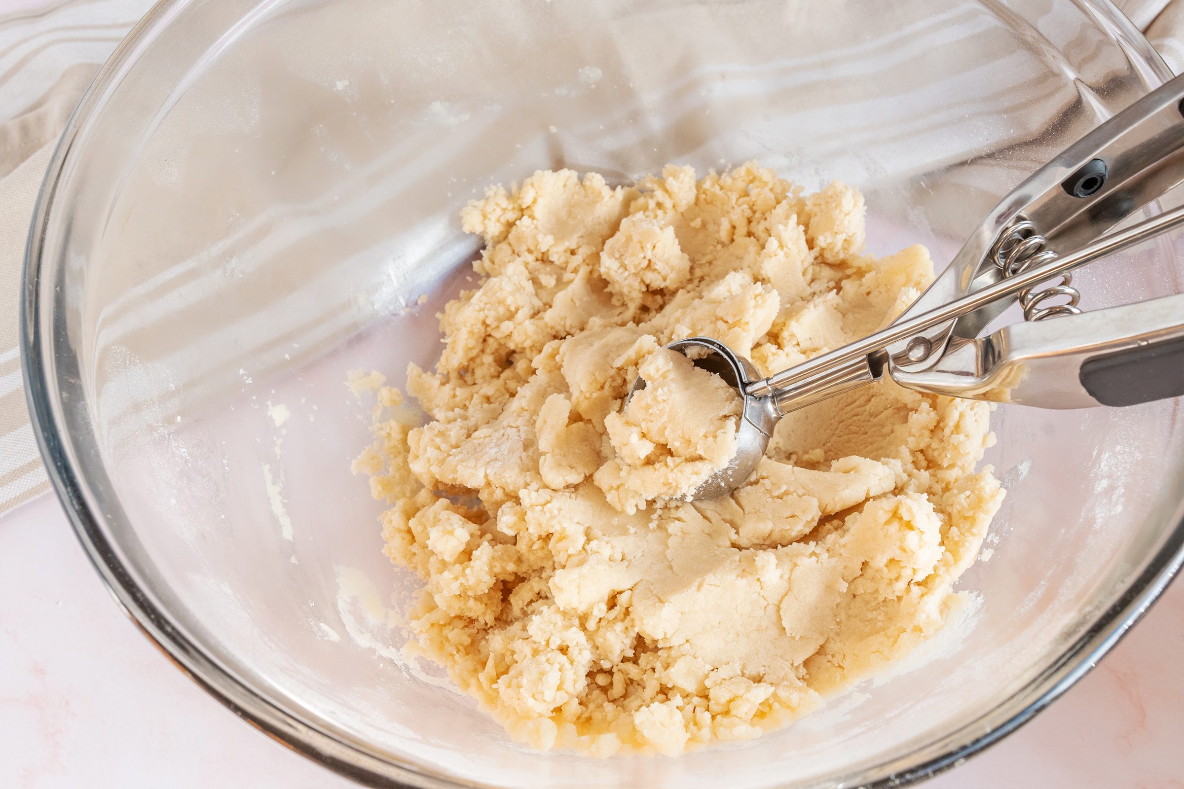 scooping dough onto cookie sheet to bake 3 ingredient sugar cookies
